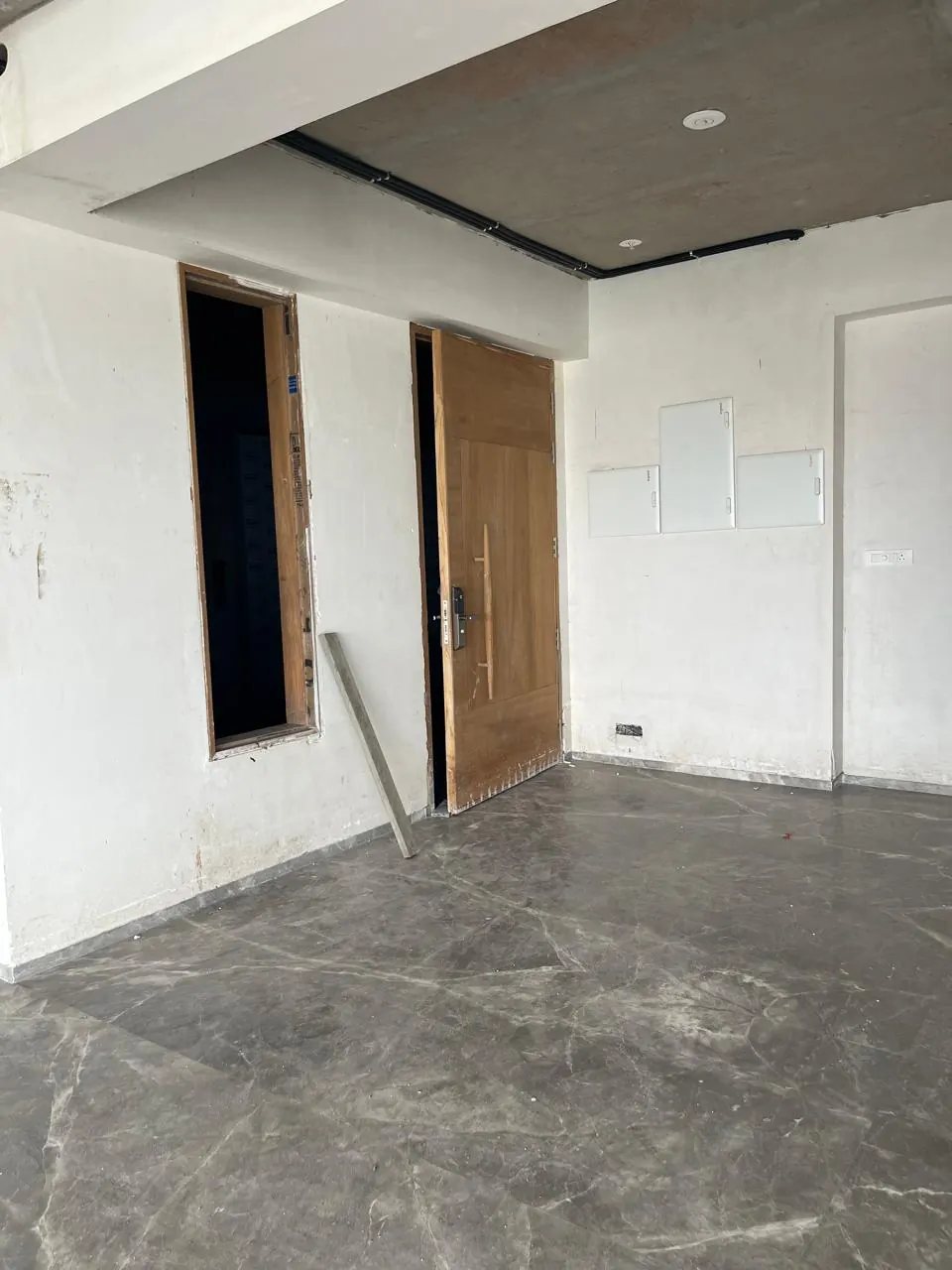 A hall on site: bare walls, the marble floor just laid.