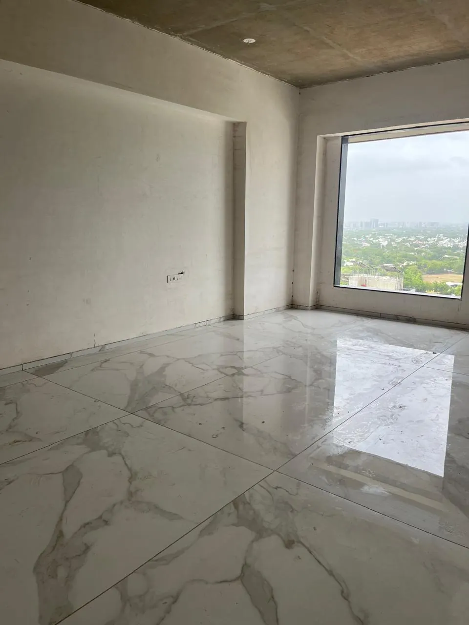 A room on site: plaster, a window, marble underfoot.