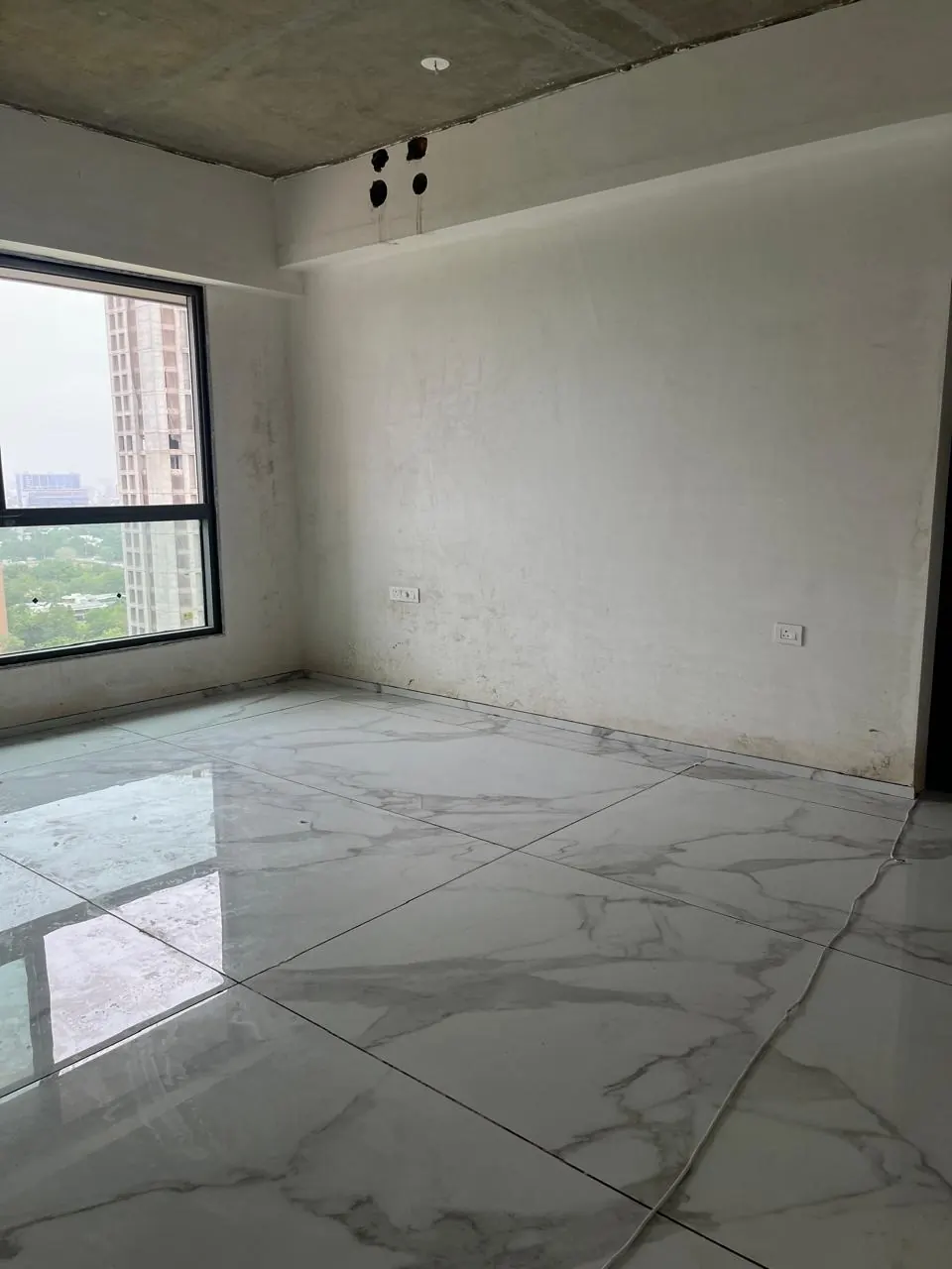 An empty room on site, the window framed in raw plaster.