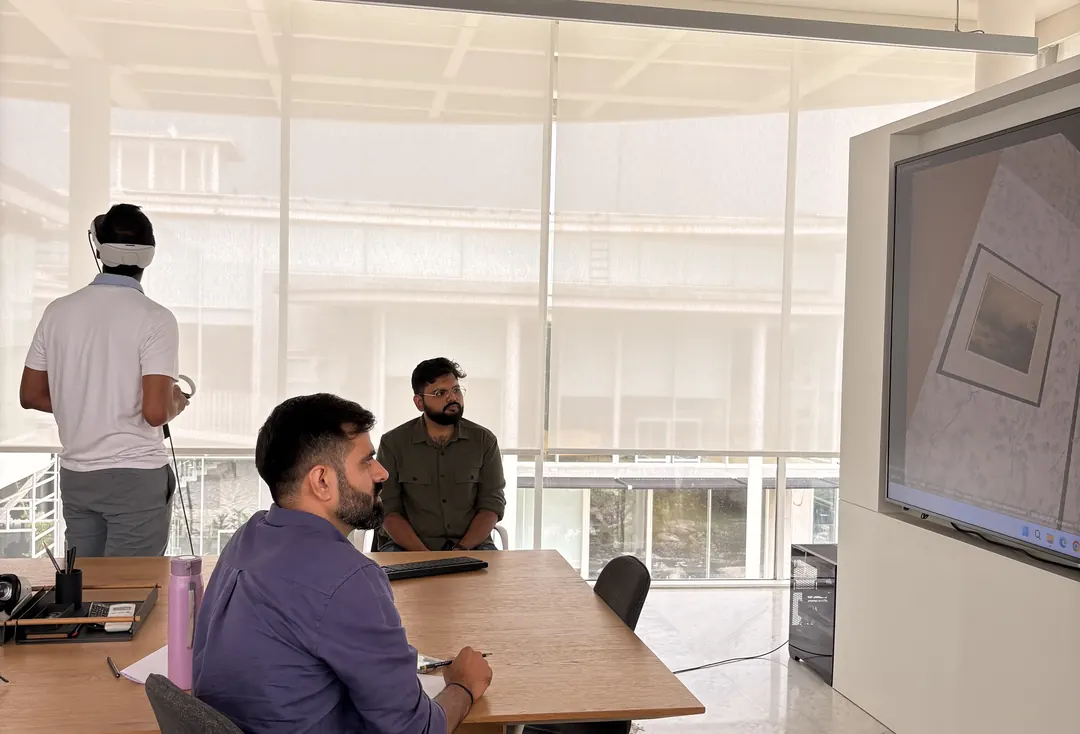A client in a VR headset walks through his future home while the studio follows on the screen.