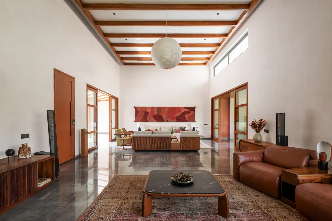 A living room under timber beams, a paper lantern.