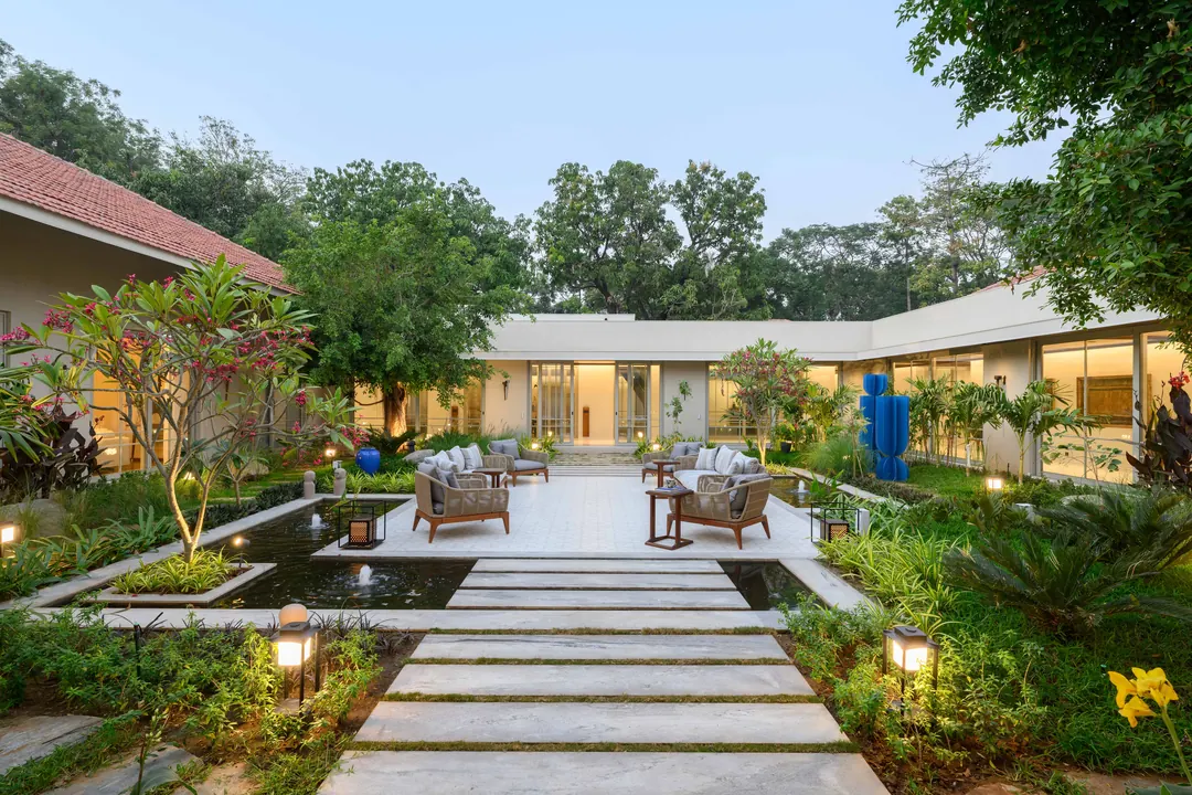 A courtyard garden, a stone path between planted beds and water.