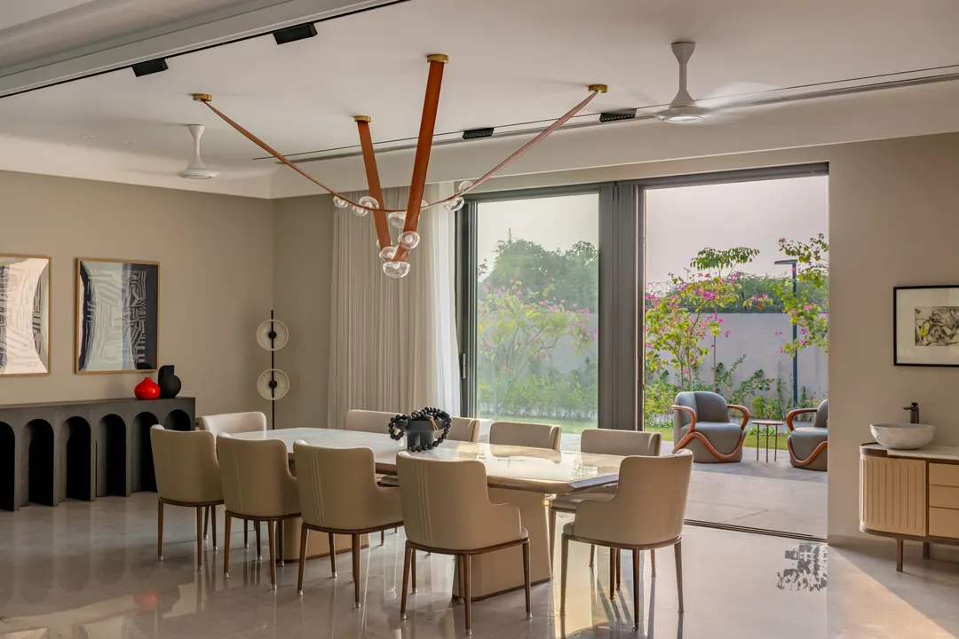 A dining room under a brass chandelier, glass to the garden.