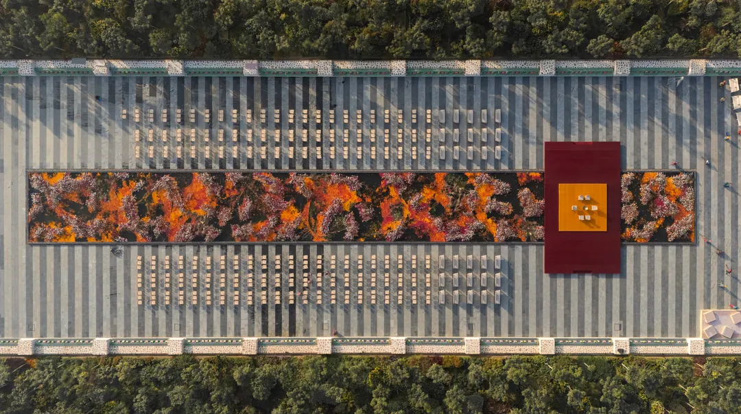 From above: the long water at A Note of Zen filled with flowers for a wedding, guests seated on both sides.