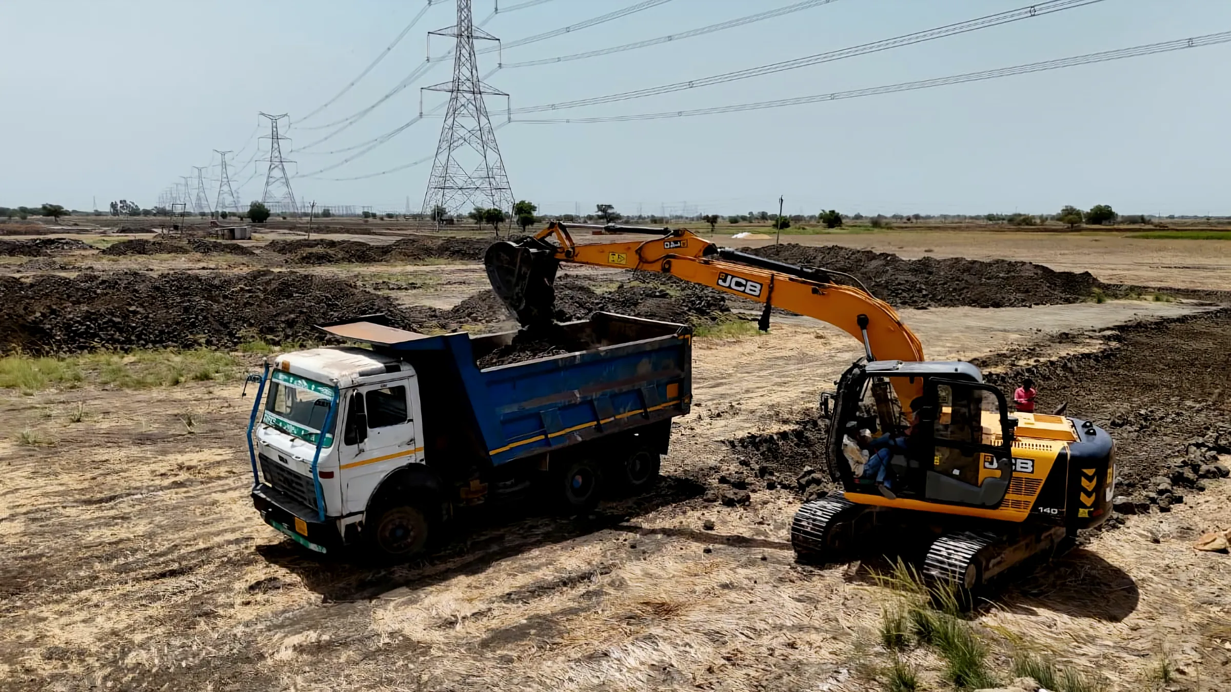 Earthwork on one of our sites: an excavator loads a tipper truck.