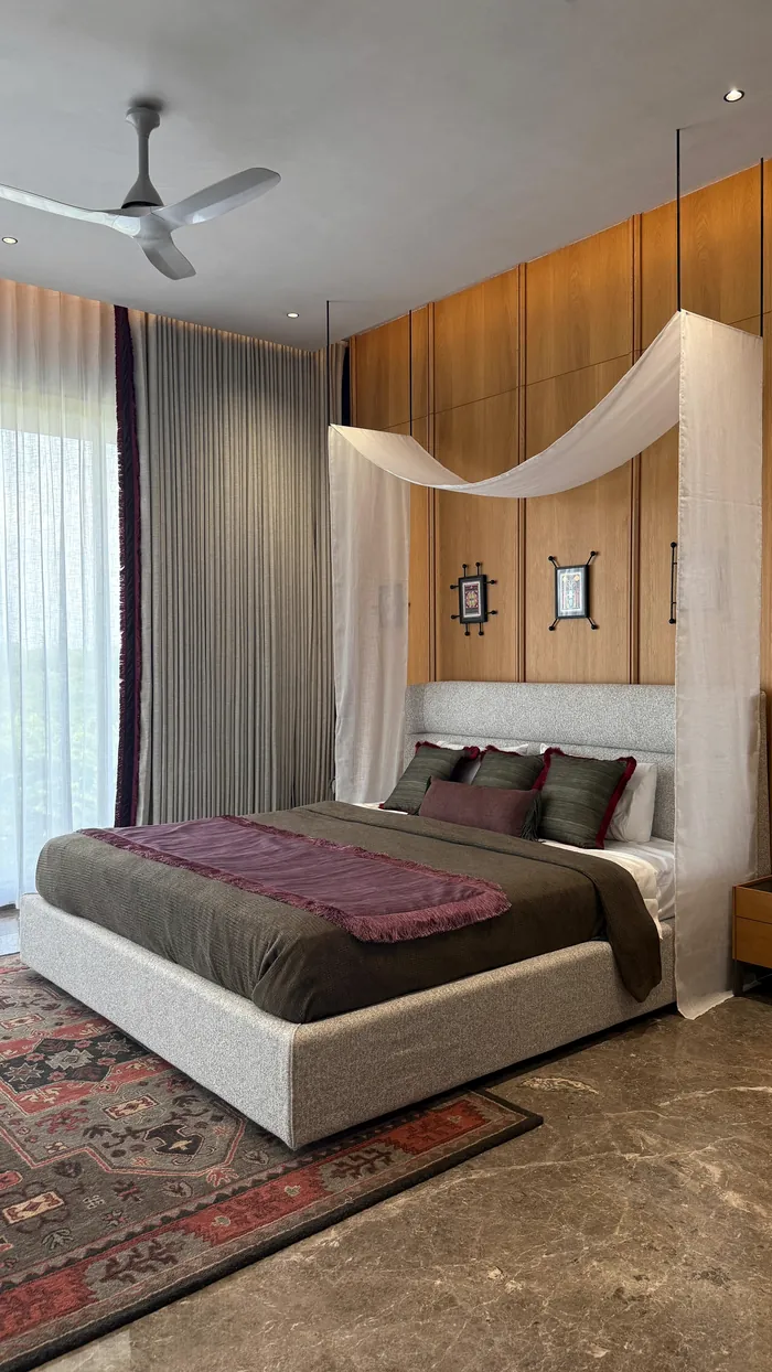A bedroom with a white canopy, timber behind the bed.