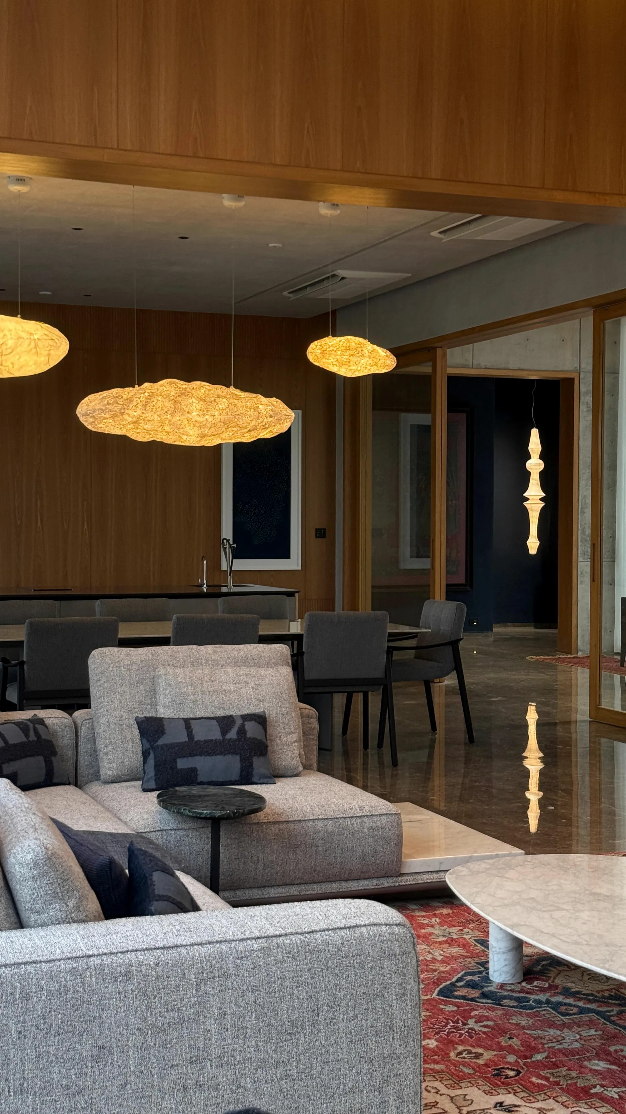 A home handed over: a timber room under clouds of light, the dining table beyond.