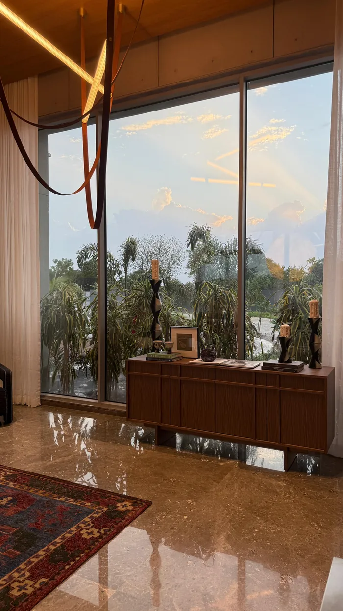A window wall at dusk, a sculpture on a low cabinet.