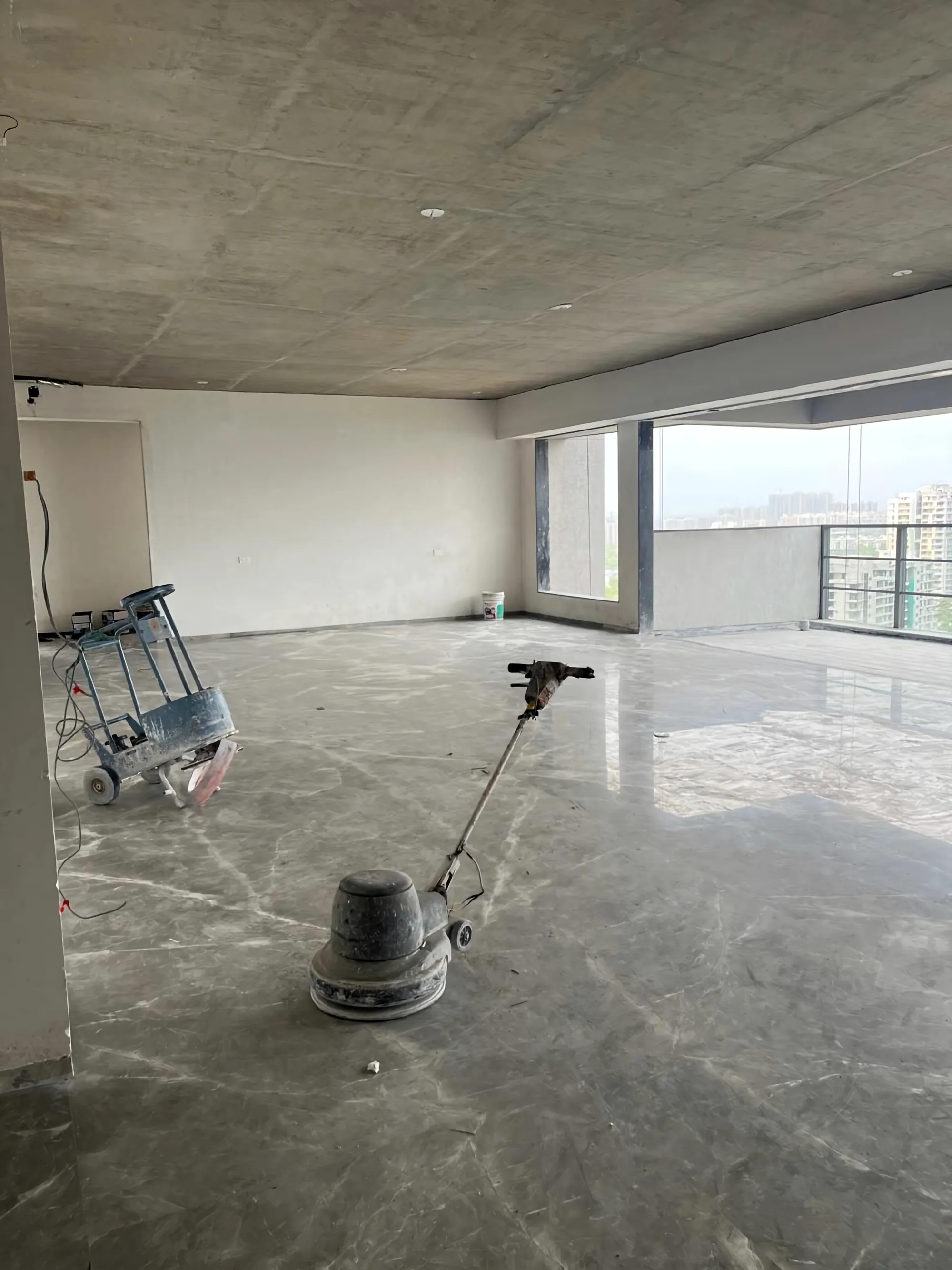 A marble floor being polished on site, light through tall windows.