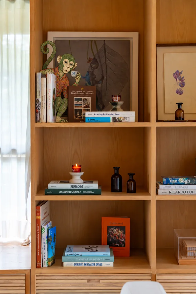 A small painted monkey reading on the library shelf